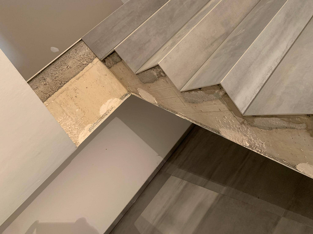 Treppenverkleidung mit grossformatigen Platten aus dem Material Infinity Light di Limestone auf Gehrung