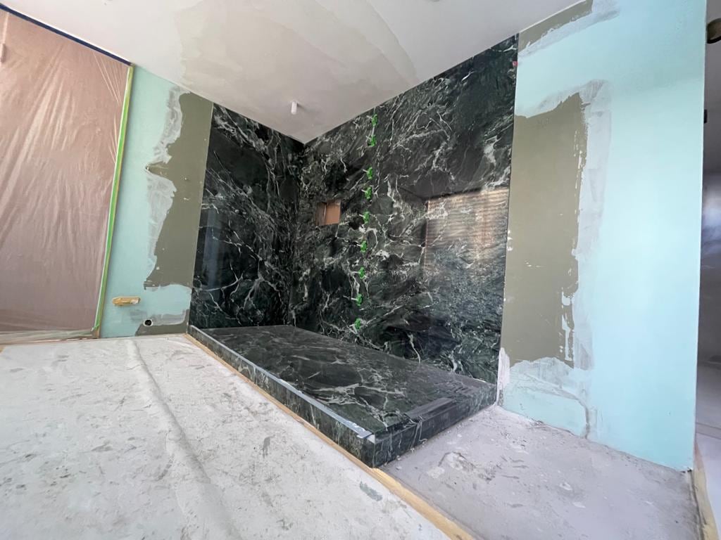 Badezimmer mit moderner Dusche aus dem Material Level Verde St. Denis
