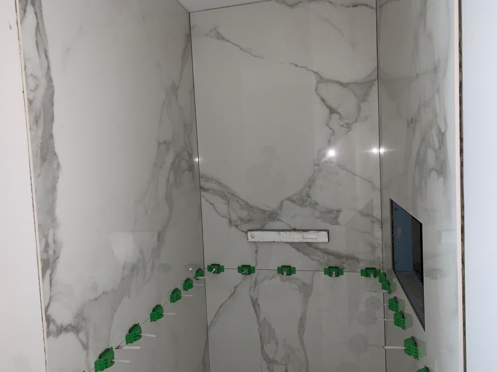 Dusche mit grossformatigen Platten auf Wand und Boden  